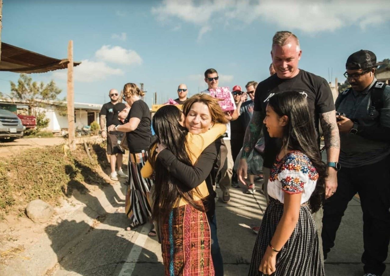 Group of people standing together, two are hugging