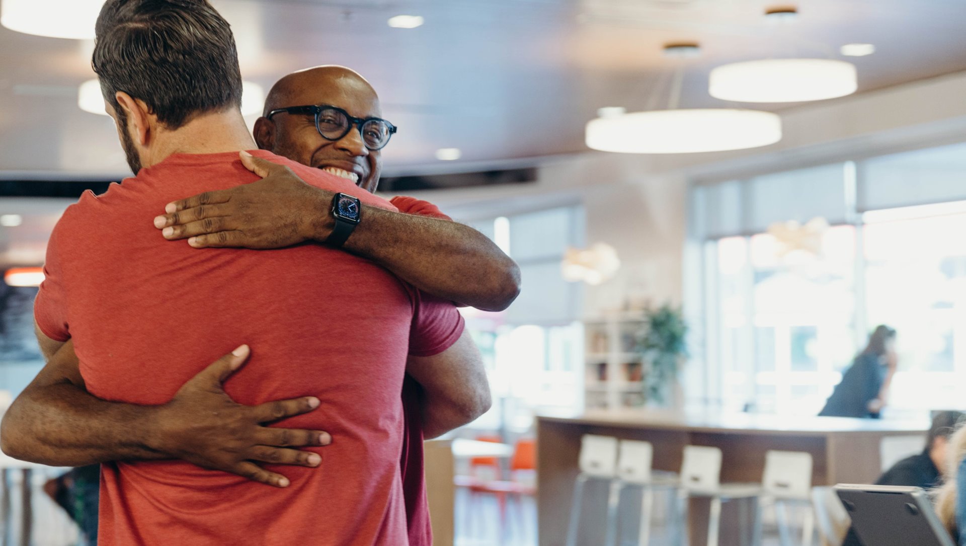 Two men hugging and smiling