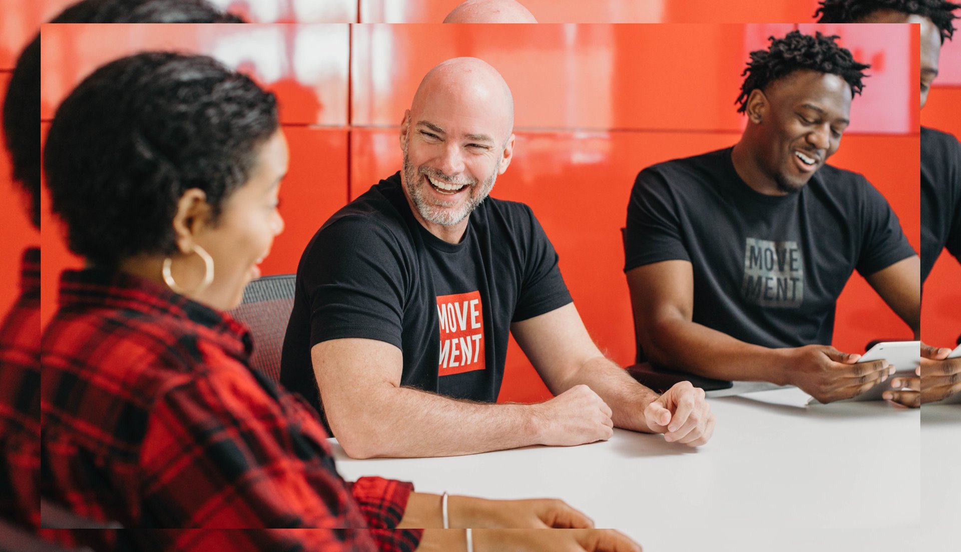Three people seated at a table laughing